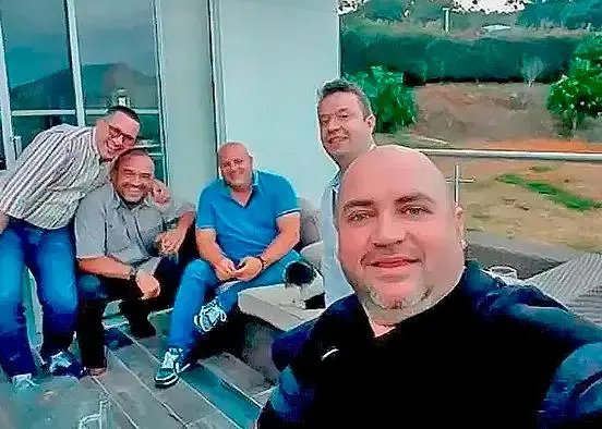 Cinco hombres presuntamente implicados en el caso AMVA posan para una fotografía en una terraza.