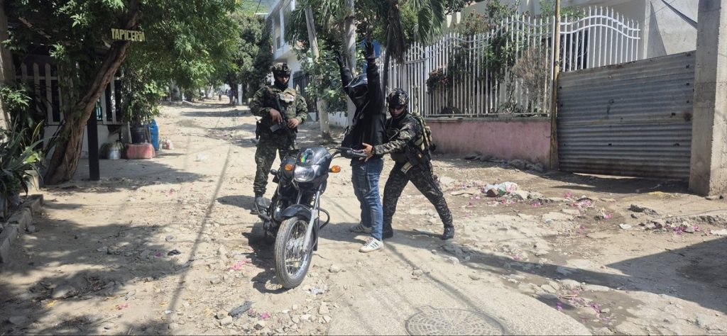 Dos soldados realizan un control a un motociclista tras militarización de Santa Marta.