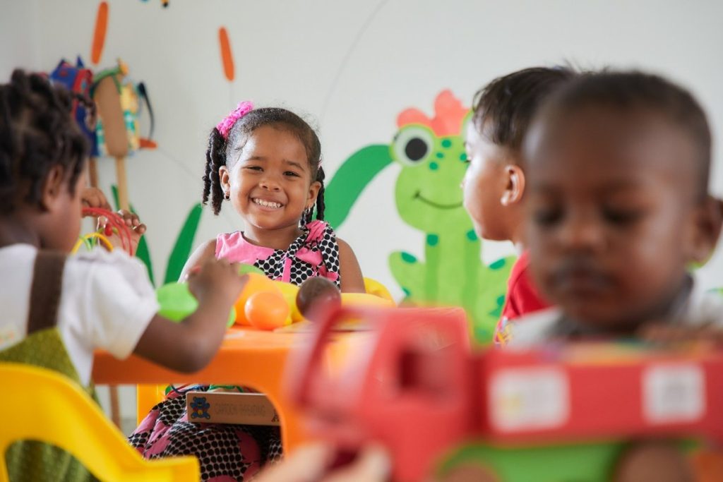 Niñas y niños comparten juegos alrededor de una mesa en un espacio infantil. Referencia a niños en caso de captura en Medellín.