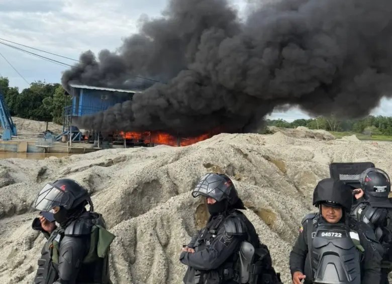 Uniformados frente a maquinaria en llamas durante un operativo contra la minería ilegal en El Bagre.