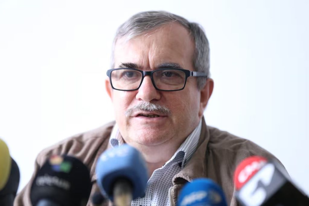 Rodrigo Londoño, conocido como Timochenko, frente a micrófonos de varios medios. Referencia a sanción a Timochenko.