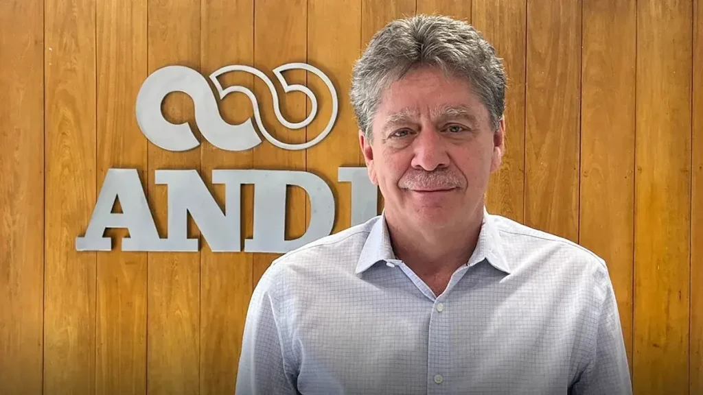 Bruce Mac Master frente al logo de la ANDI.
