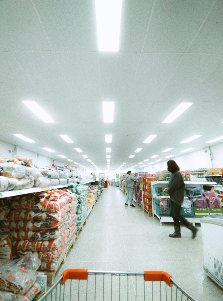 Pasillo de un supermercado de Rionegro con compradores y un carrito en primer plano. Referencia a inflación en Colombia