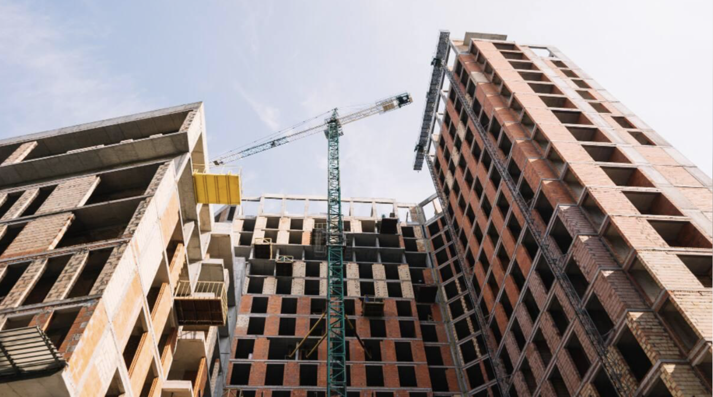 Torres de apartamentos en construcción junto a una grúa. Referencia a proyectos de vivienda